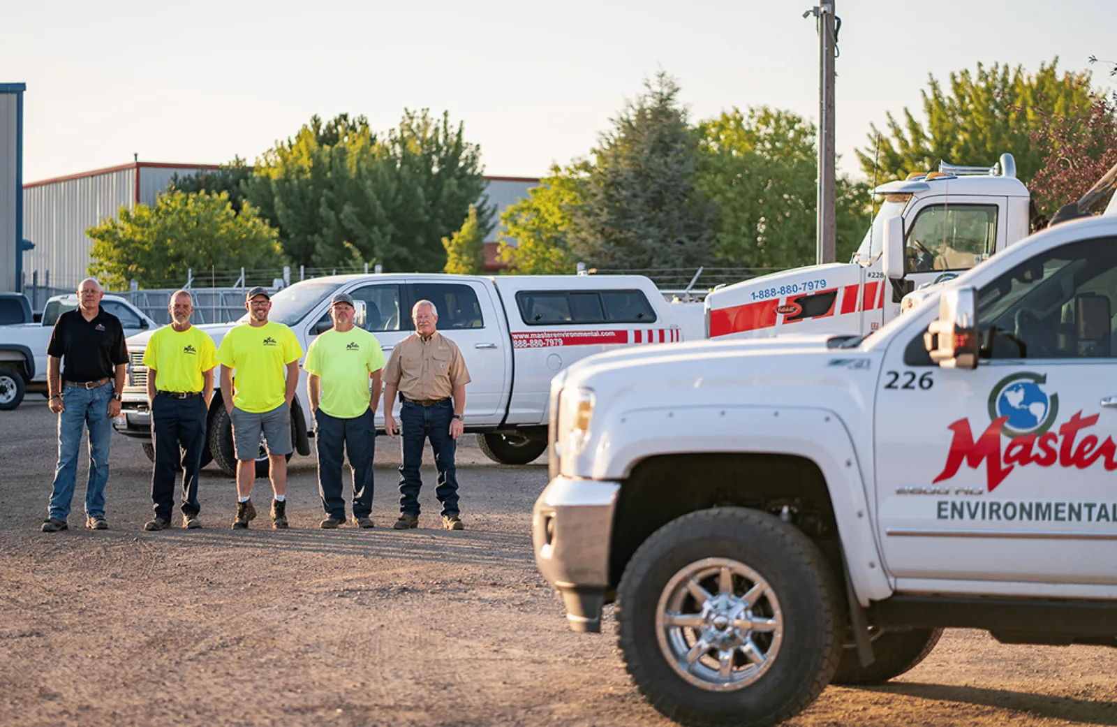 Master Environmental team standing in front of service trucks